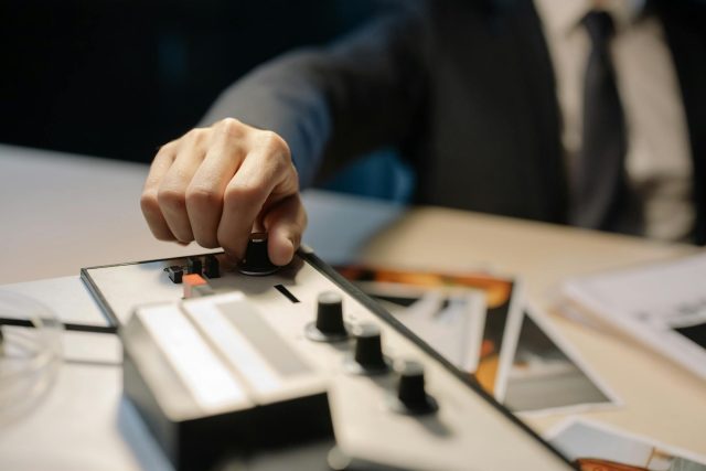 a person holding the volume knob of a recorder